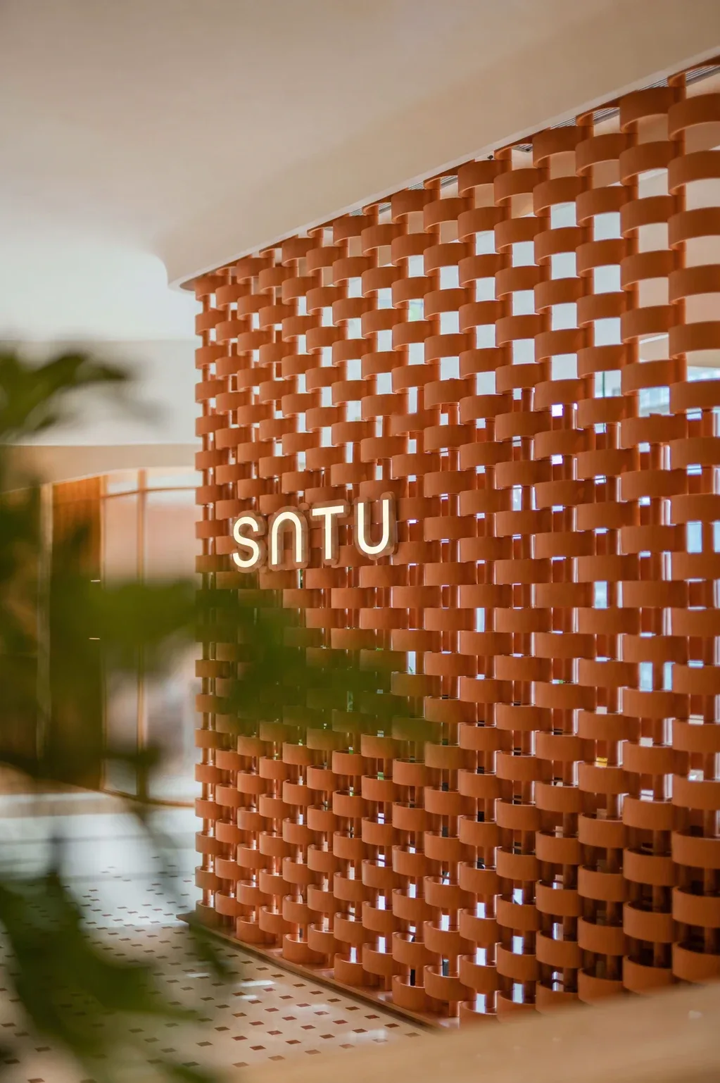 SATU identity within a sculptural terracotta screen